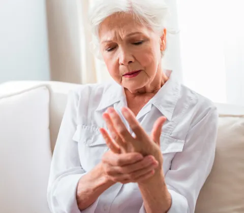 Mujer mayor sosteniendo su mano. Osteoporosis